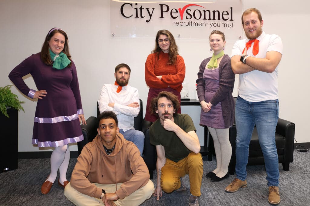 A group of City Personnel employees dressed up as characters from Scooby-Doo, posing together for a Halloween event.