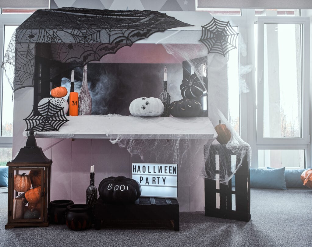 A spooky office decorated with cobwebs, pumpkins, skeletons, and eerie lighting for Halloween.